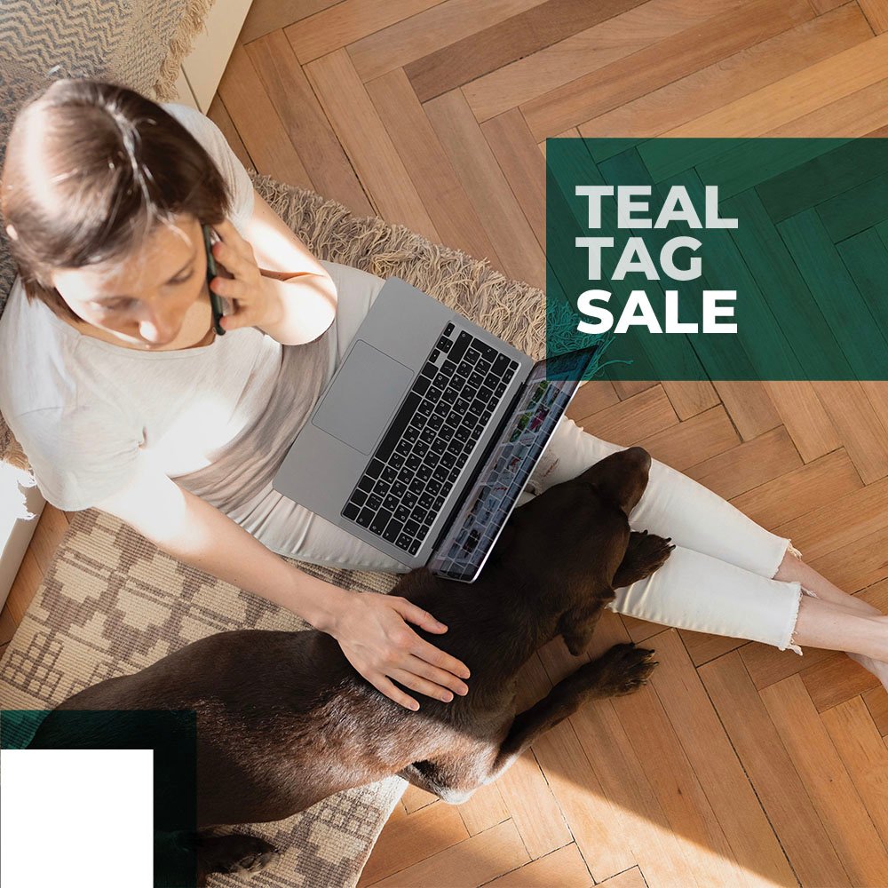 Woman Sitting on Hardwood Flooring with chocolate lab in lap, online shopping while talking on phone